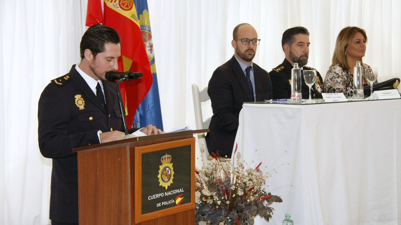 Imagen del agente encargado de presentar el acto (en el atril). Al fondo ( y de izd. a dcha.): Germán Beardo, Gonzalo Bellver y Elena Amaya.