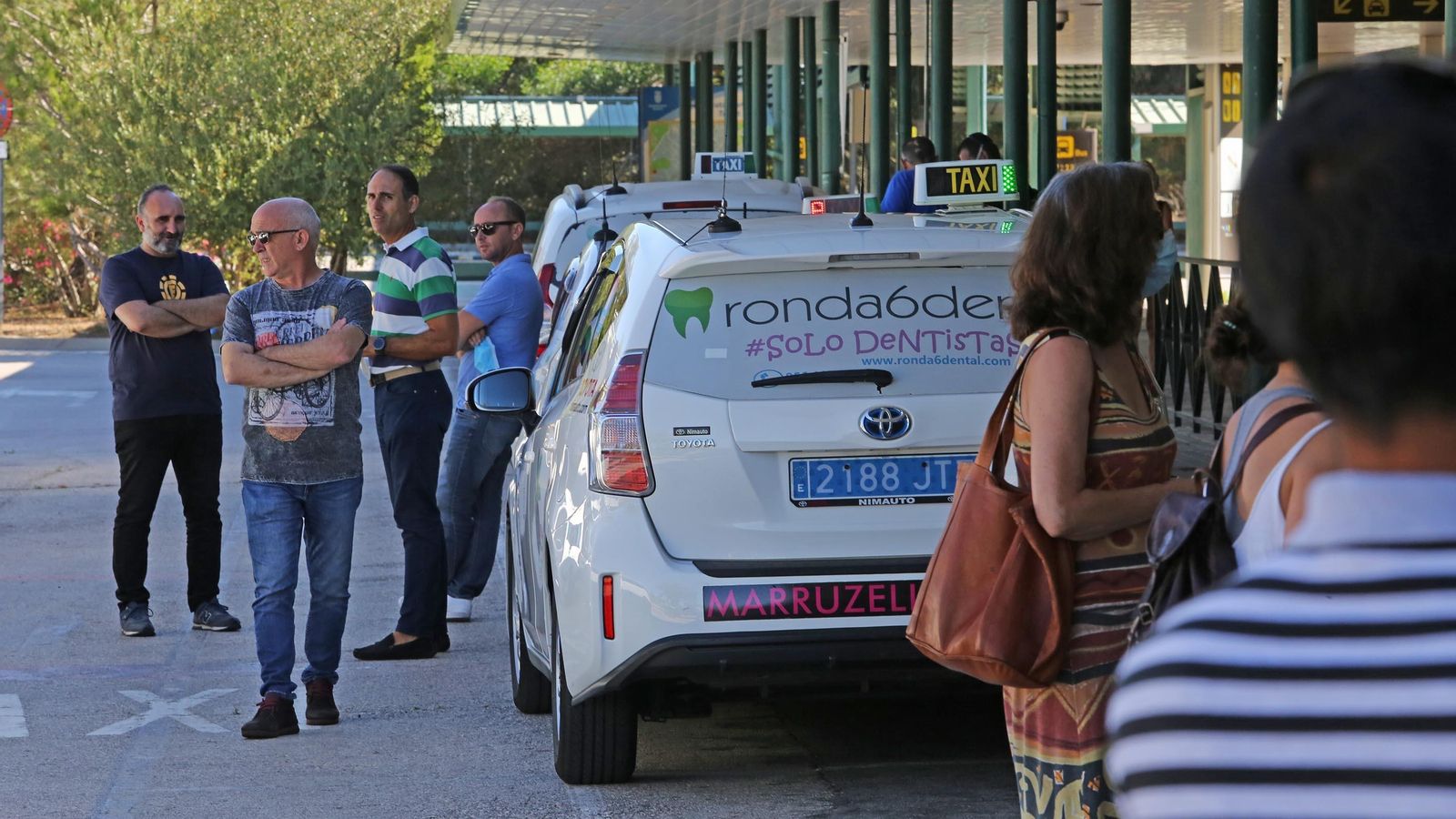 Taxistas esperan clientes en la parada del aeropuerto.
