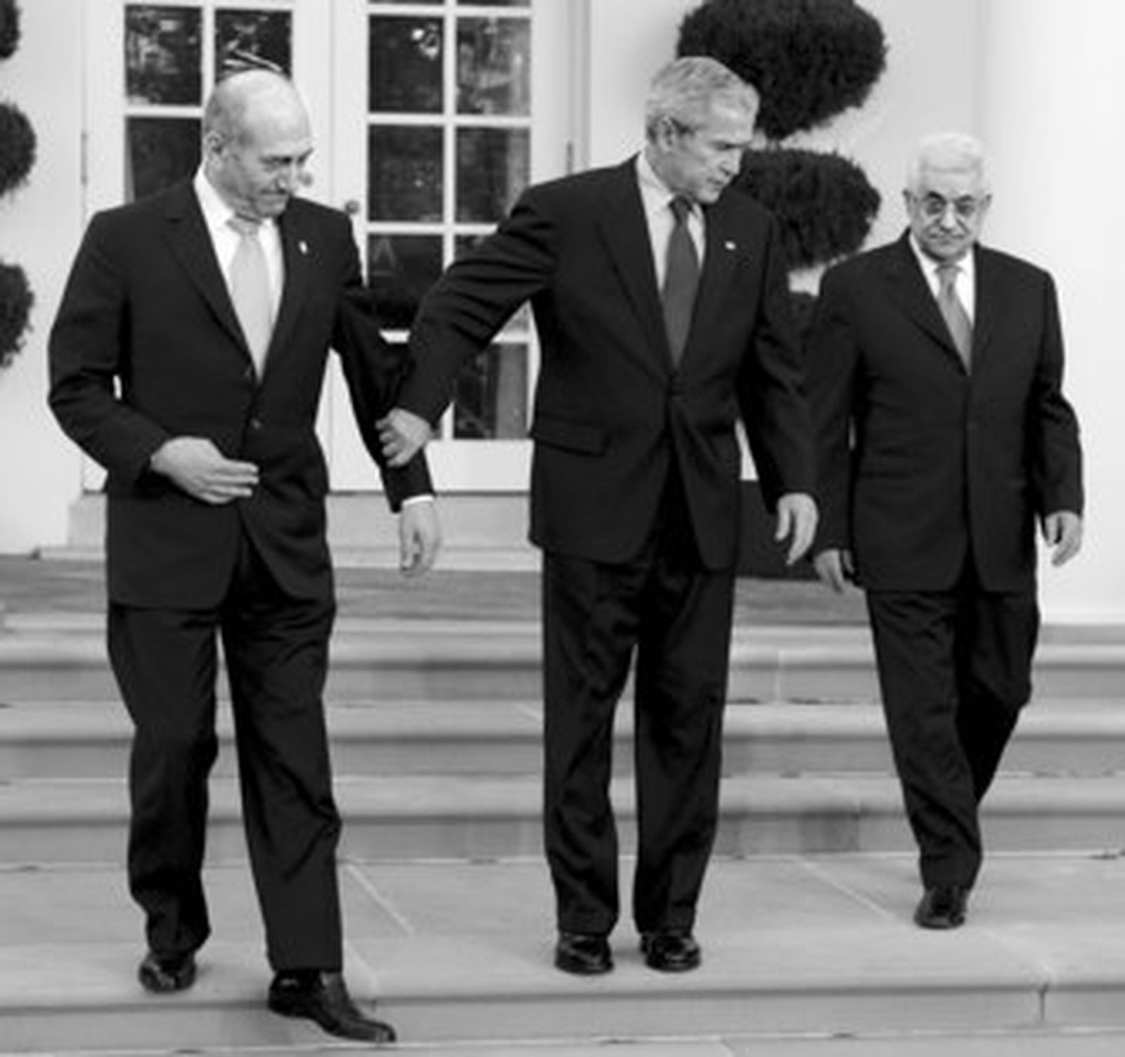 Bush atrae junto a él a Olmert y a Abbas antes de posar en el jardín de la Casa Blanca.