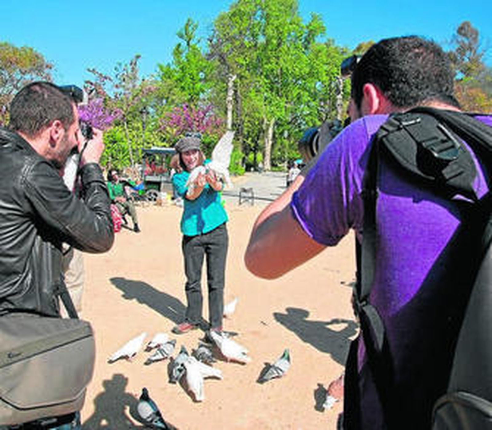 Fotógrafos de Sevilla Photo Tour retratan a una turista en el Parque María Luisa.