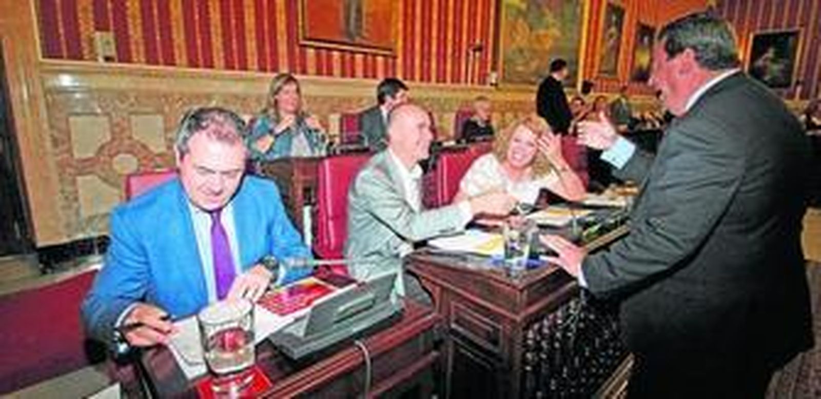 El concejal del PP Ignacio Flores conversa con los ediles socialistas Antonio Muñoz y Adela Castaño, en presencia del alcalde, Juan Espadas.