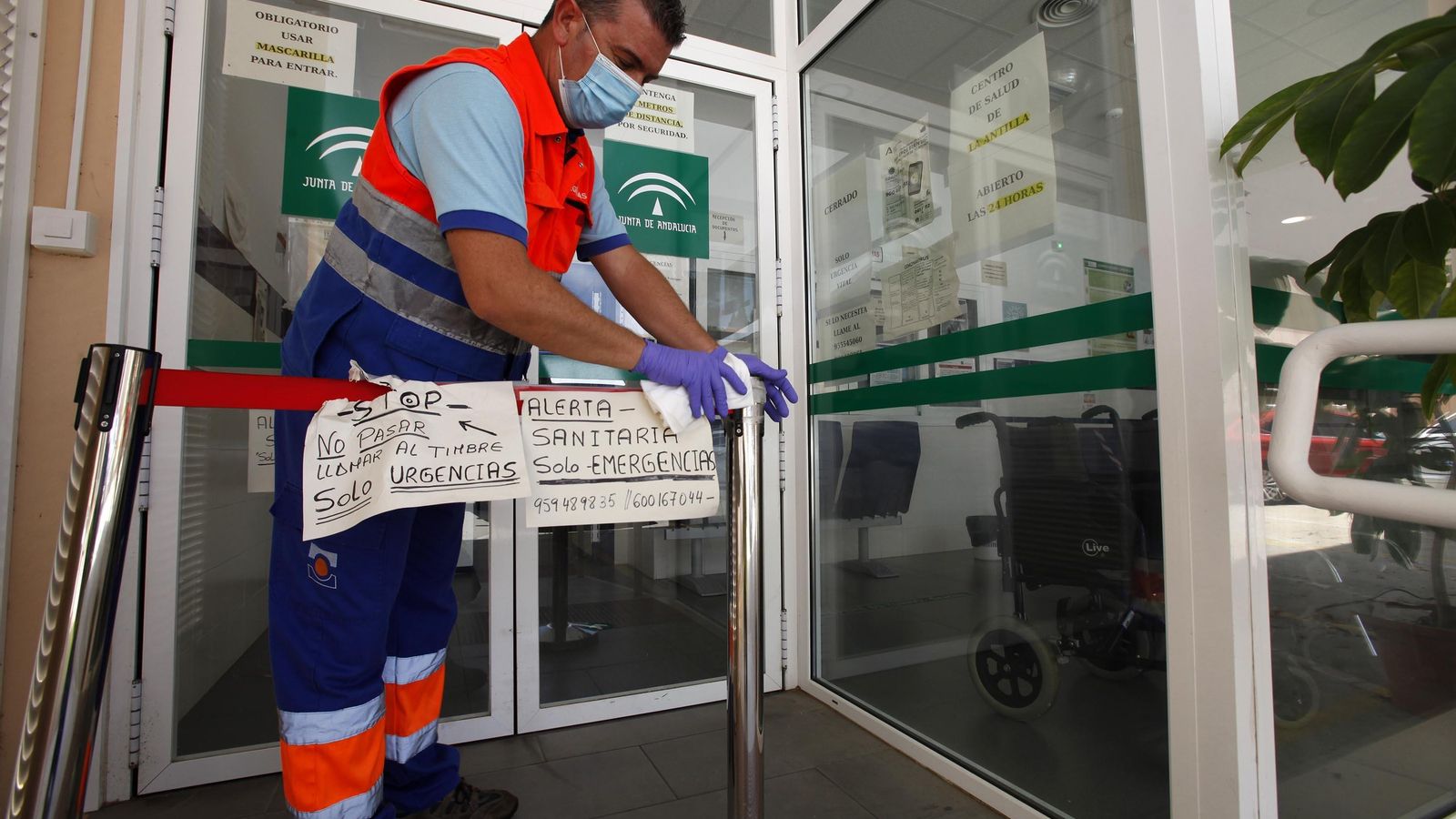 Un celador desinfecta la entrada a uno de los centros de salud del distrito Huelva-Costa durante la presente pandemia