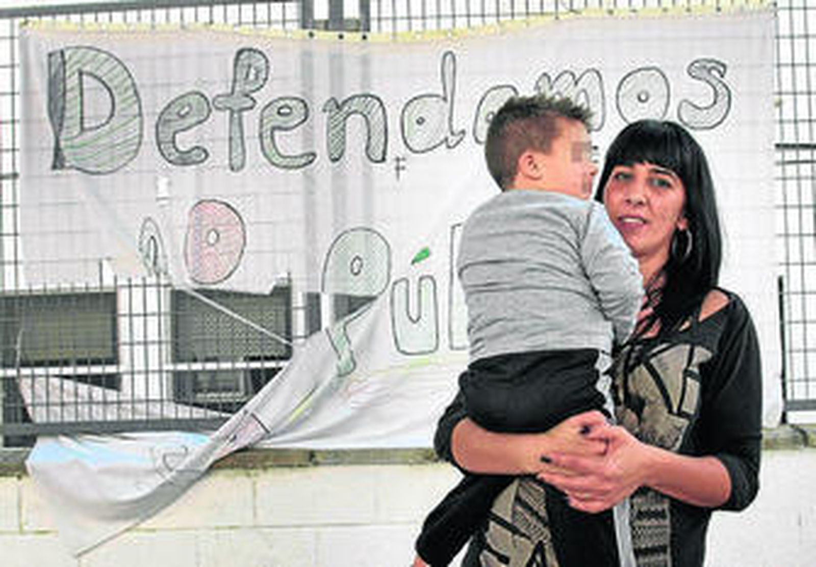 El niño con su madre en el centro educativo del que se despide hoy.
