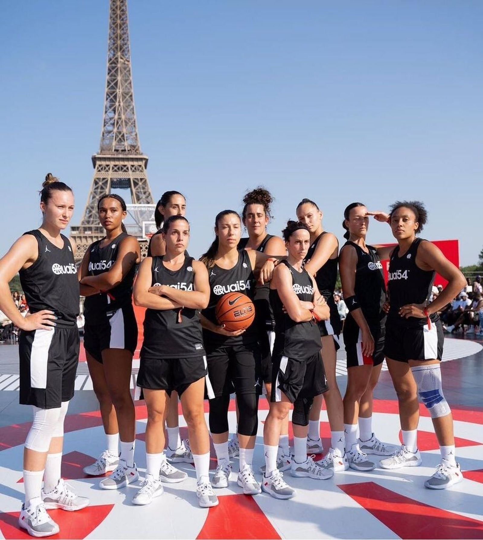 El equipo femenino de El Palo posa con la torre Eiffel de fondo.