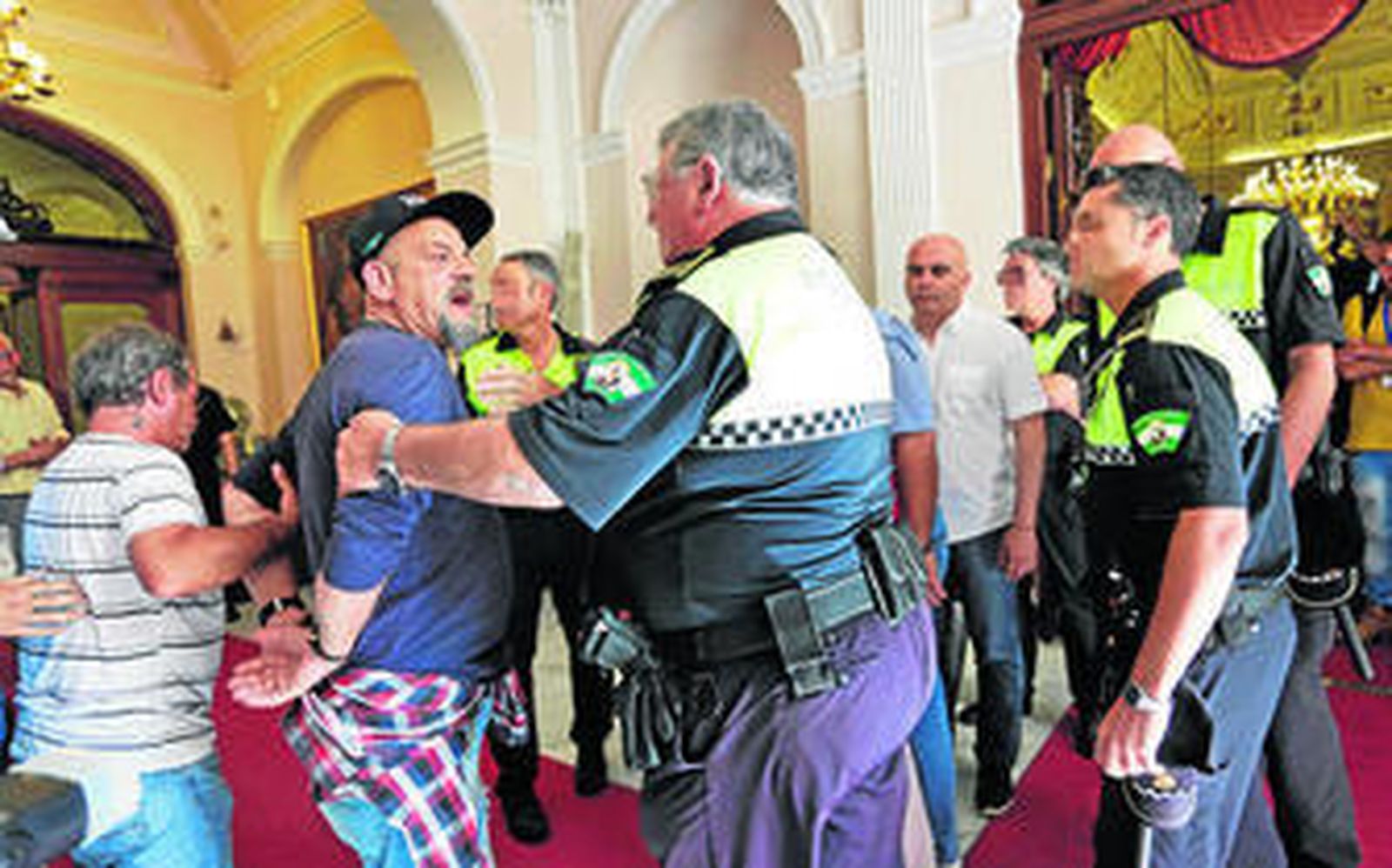 Un miembro del colectivo de desempleados se encara con otra persona en el exterior del Salón de Plenos.