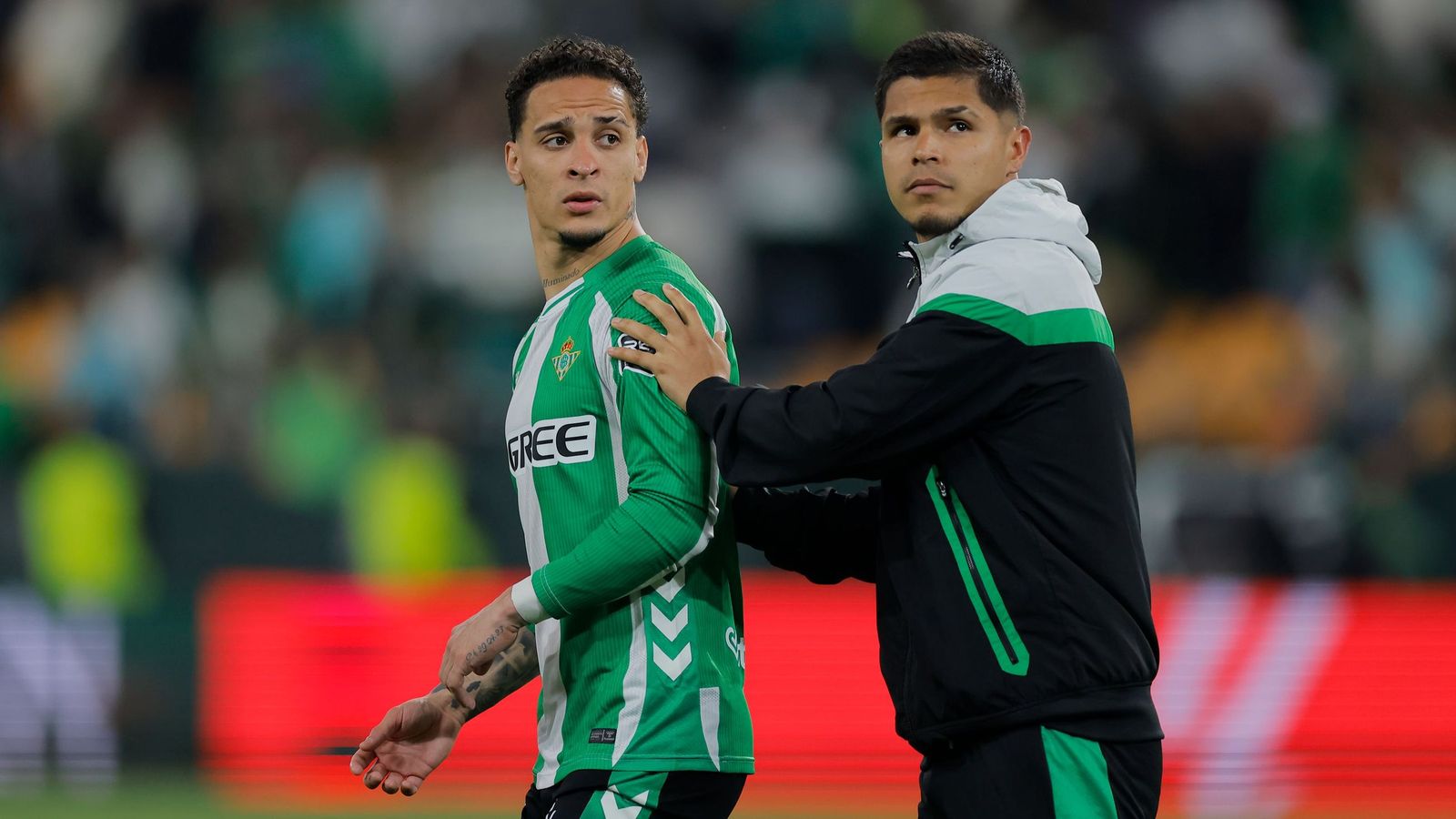 Cucho Hernández aparta a Antony de la grada tras el intercambio de opiniones con algunos aficionados.