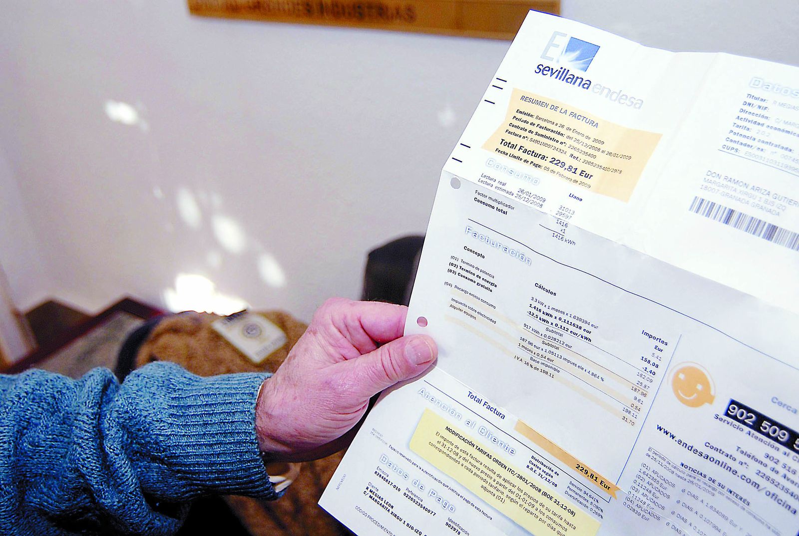 Un usuario muestra un recibo del consumo eléctrico.