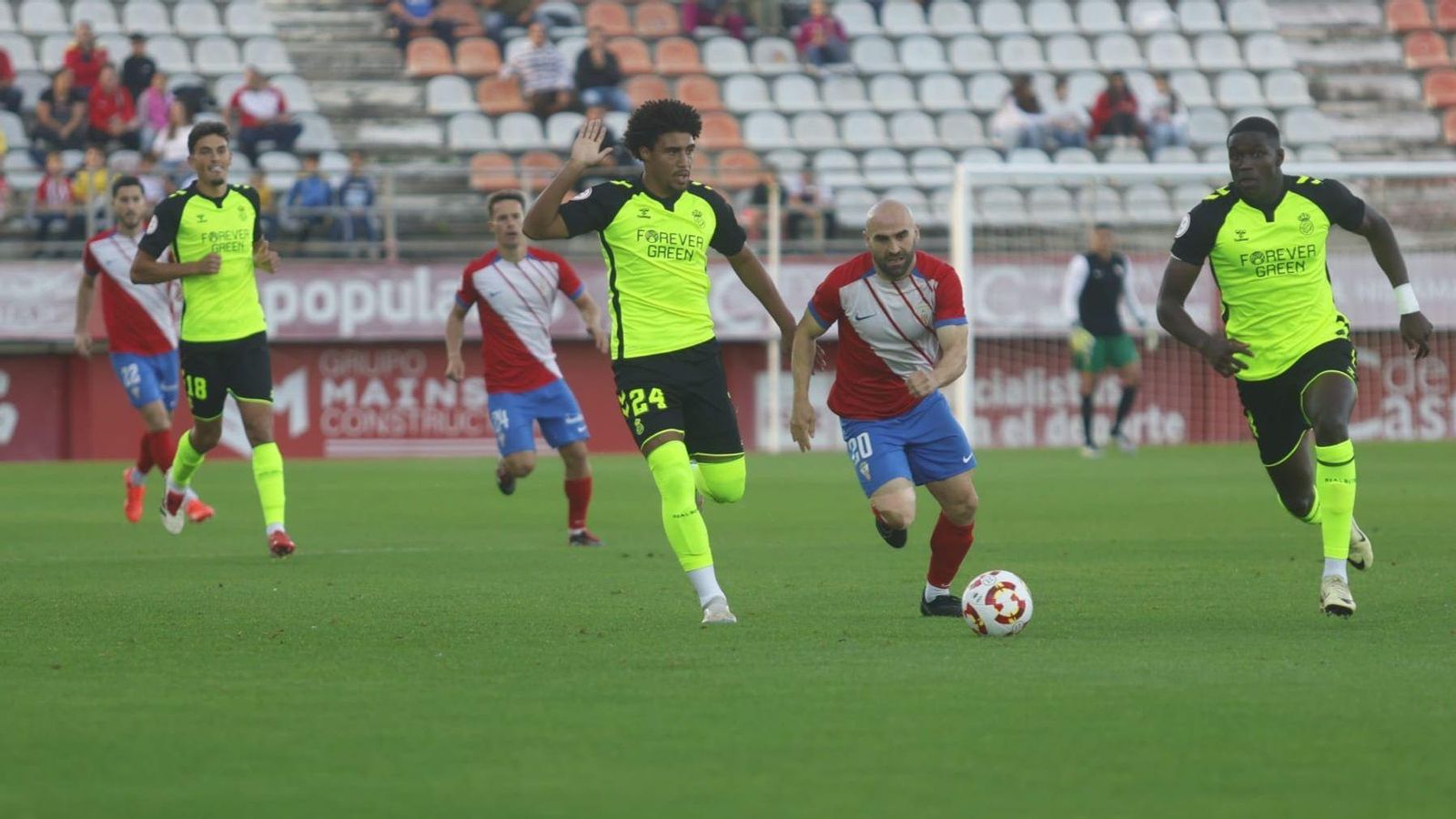 Paris Adot, ante dos jugadores del Betis Deportivo.