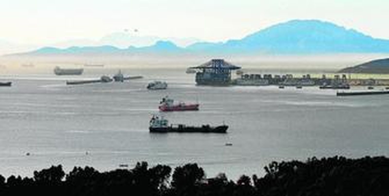 Barcos fondeados en la Bahía de Algeciras y, al fondo, el Estrecho de Gibraltar, con una densa niebla y la posible condensación de gases procedentes de los buques.
