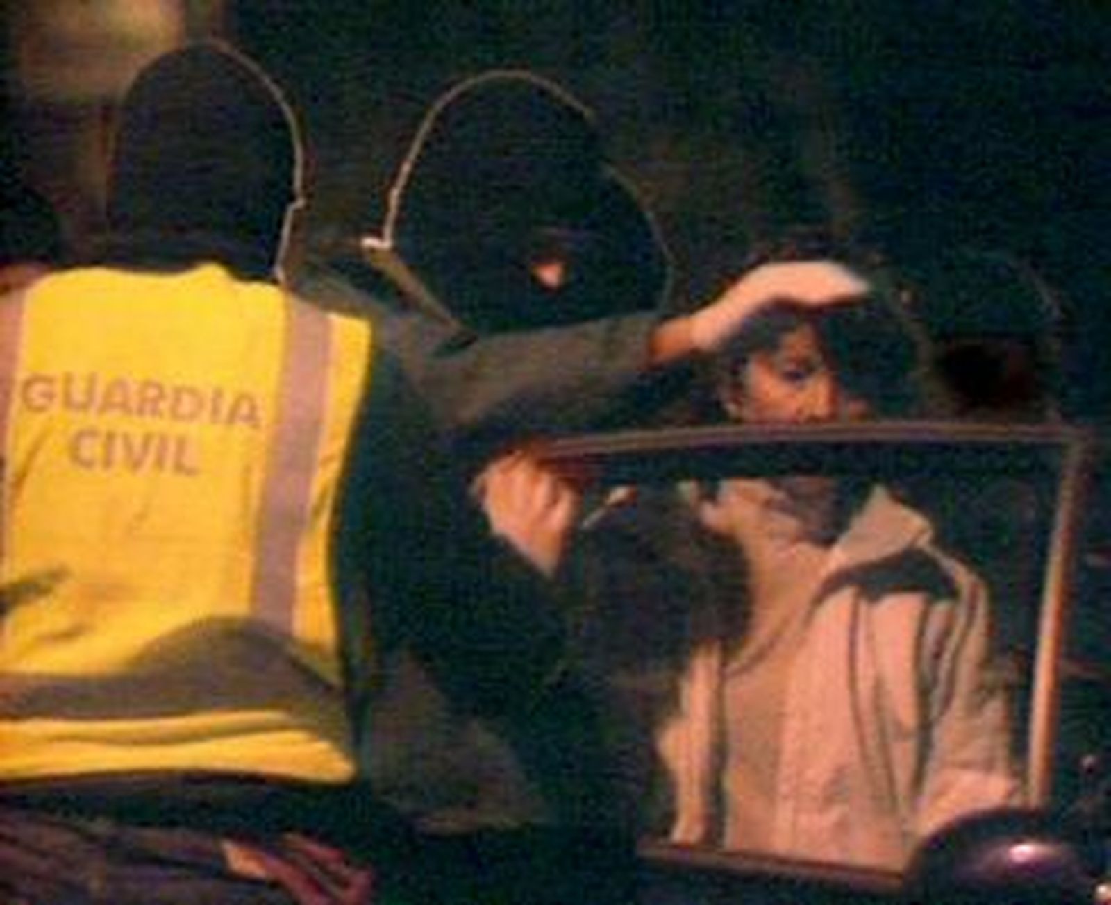 Las detenidas son introducidas en un coche policial tras su arresto.