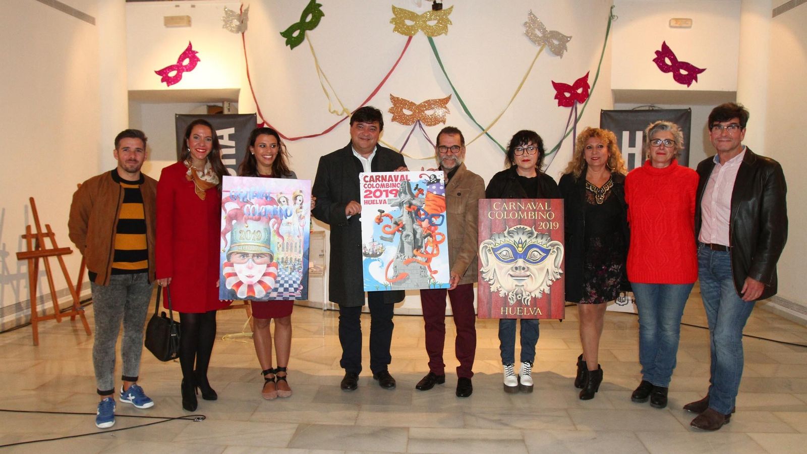 Los asistentes al acto de elección del cartel con la obra ganadora y los dos accésit