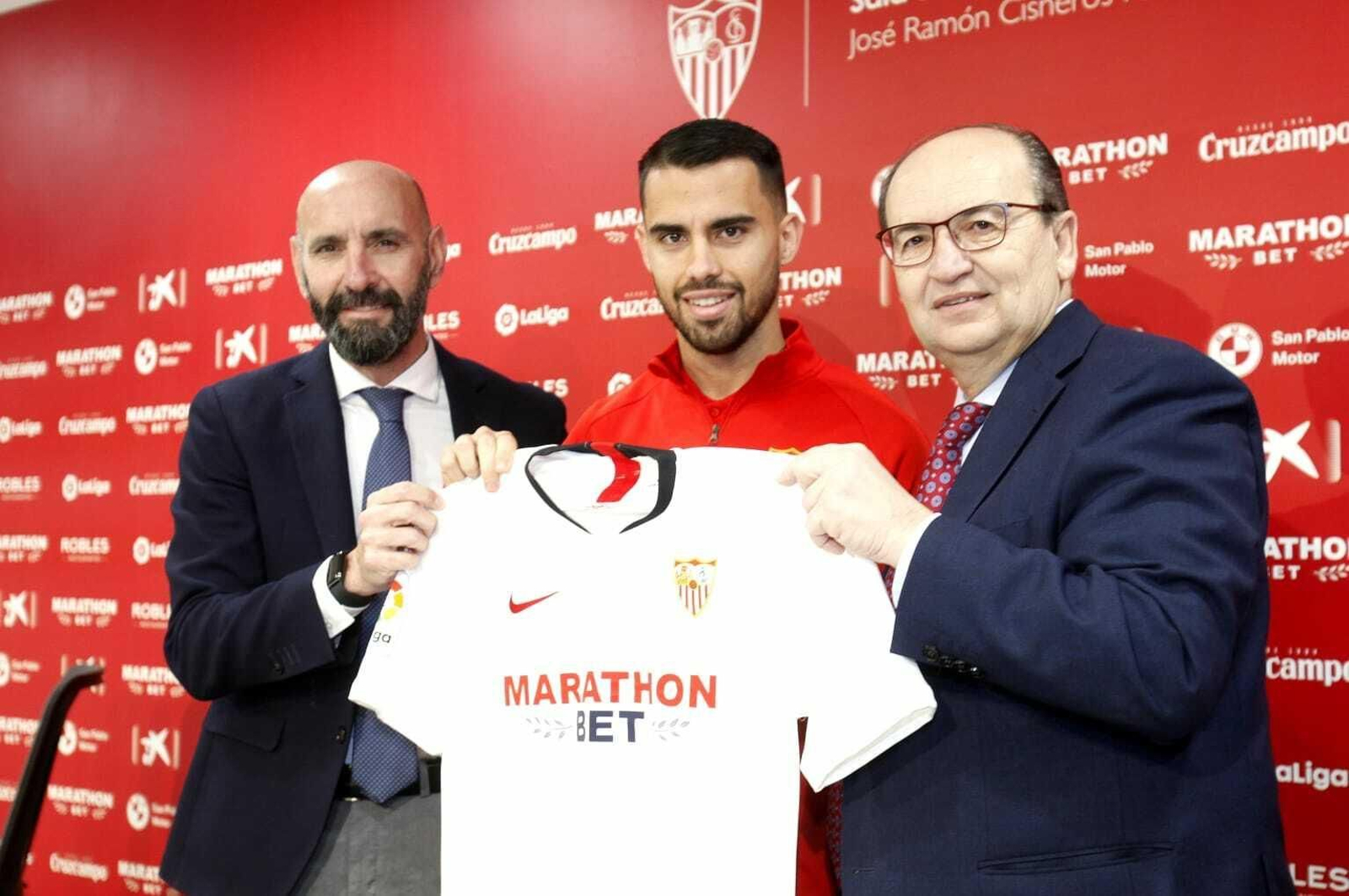 Suso muestra su  nueva camiseta junto a Monchi y José Castro.