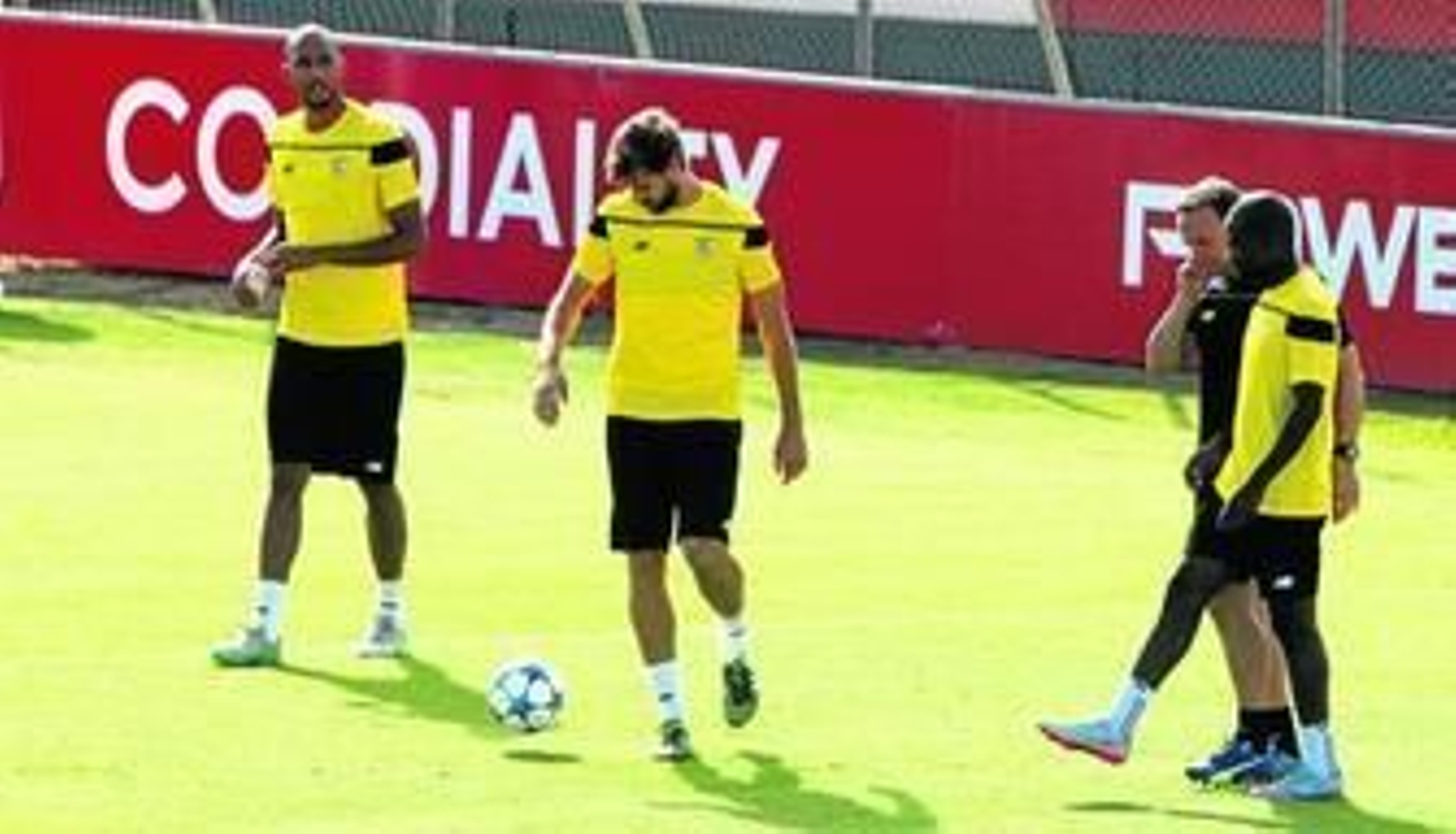 Fernando Llorente, atracción en su segundo partido en el Sánchez-Pizjuán, controla el balón junto a N'Zonzi. A la derecha, Kakuta se ejercita con uno de los preparadores físicos.