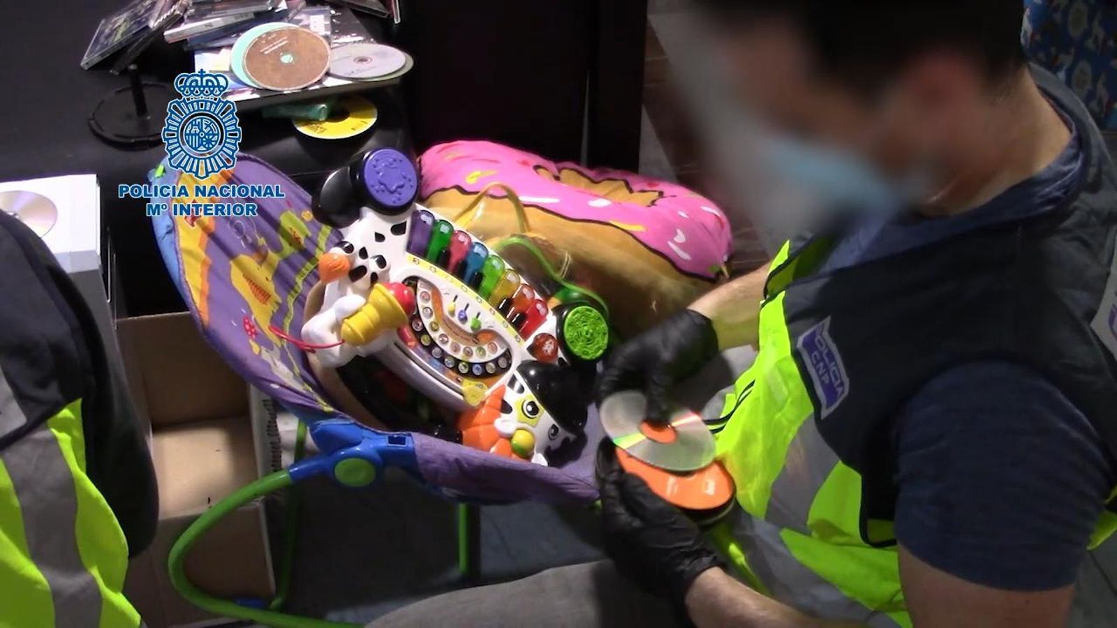 Un agente clasifica los CD intervenidos en el domicilio del detenido.