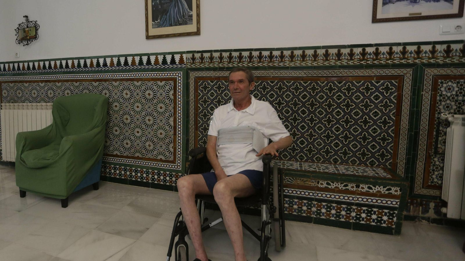 Uno de los acogidos junto a un cuadro de la Virgen de los Reyes