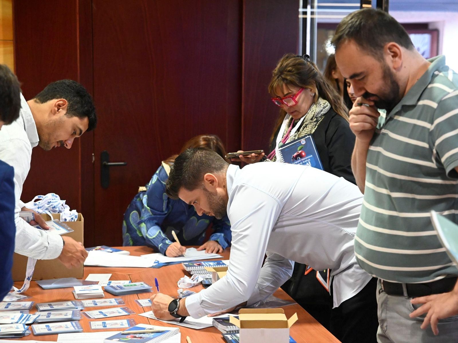 Asistentes al congreso recibiendo sus acreditaciones. Asistentes al congreso recibiendo sus acreditaciones.