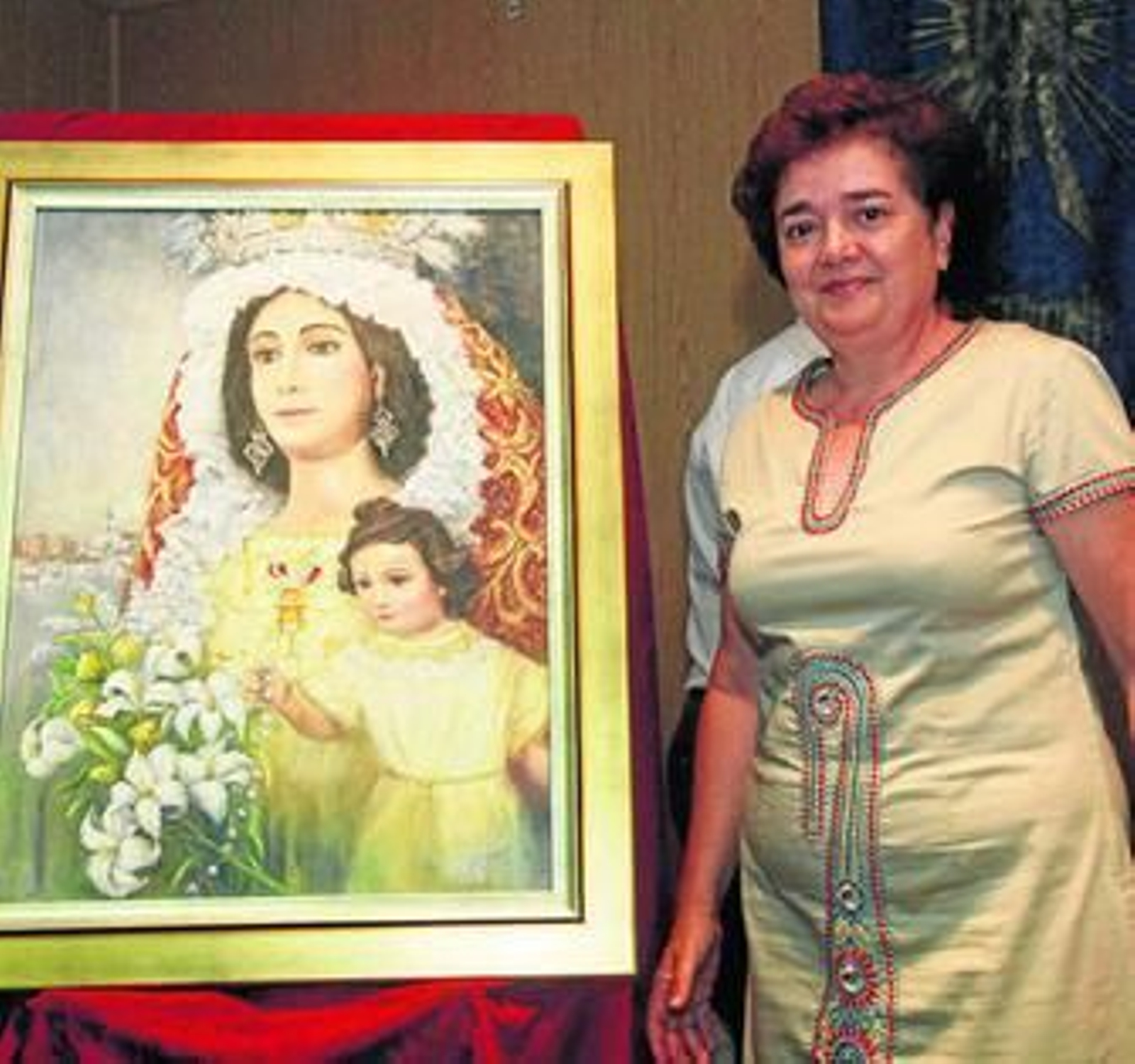 María Teresa Gómez Acevedo, junto al cartel anunciador de la fiesta.