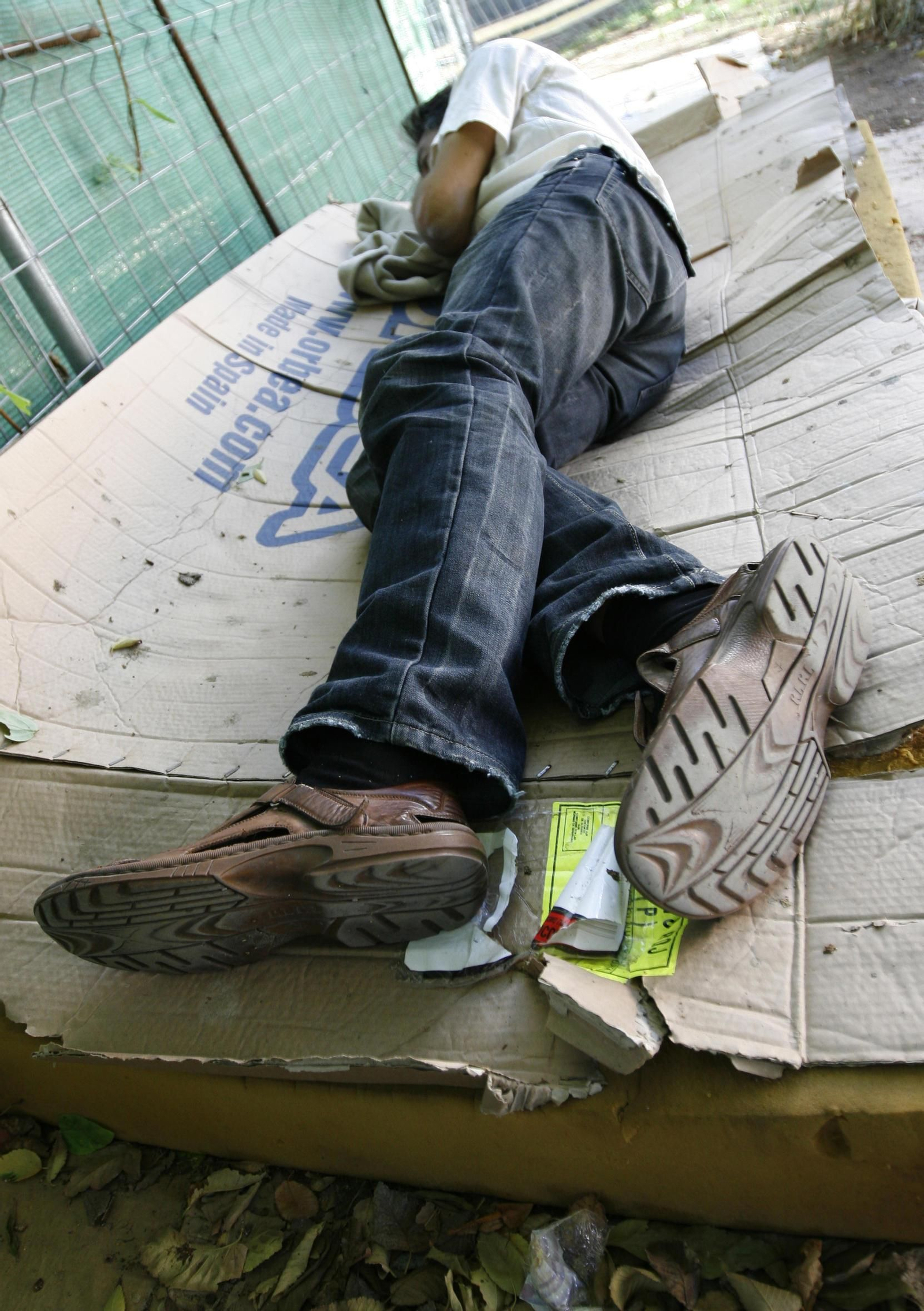 Persona durmiendo sobre cartones