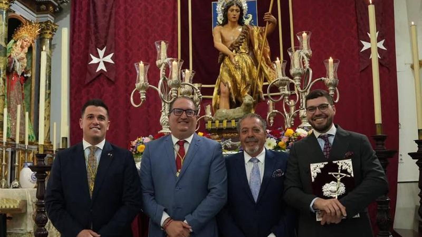 El pregonero posa ante la imagen de San Juan Bautista junto al presidente del Consejo de Hermandades y los hermanos mayores de la Patrona y el Patrón.