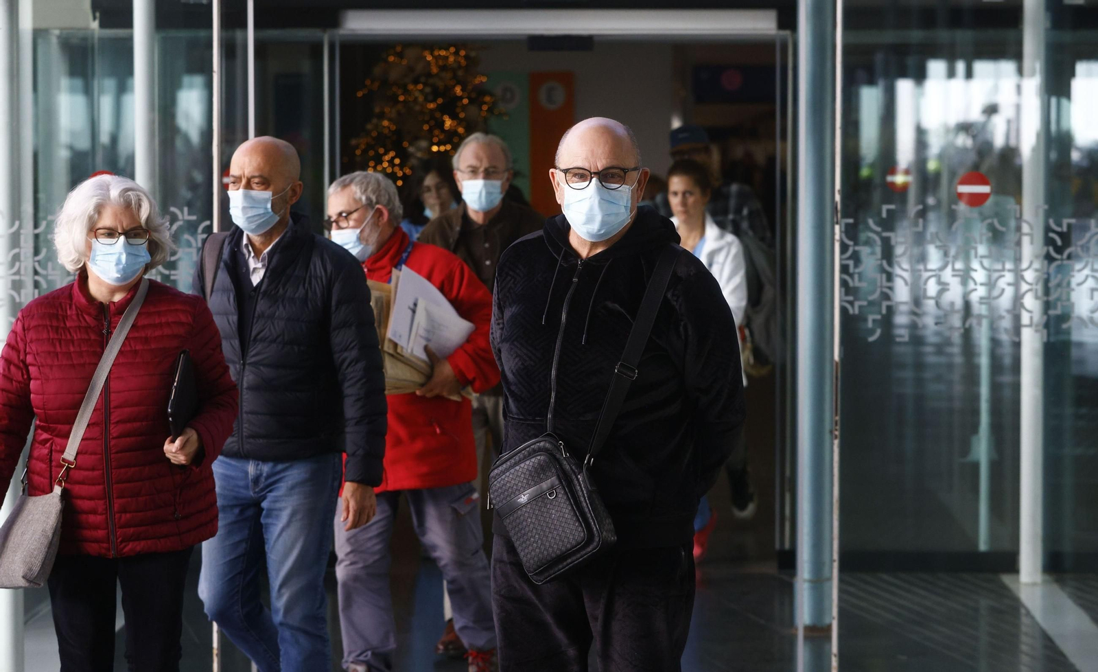 Varias personas salen con mascarilla de un centro sanitario.