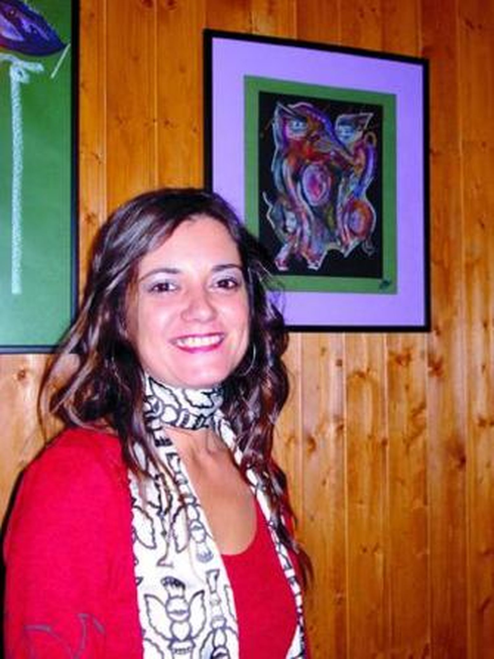 Loli Martínez, junto a una de sus obras en la taberna El Bronce.