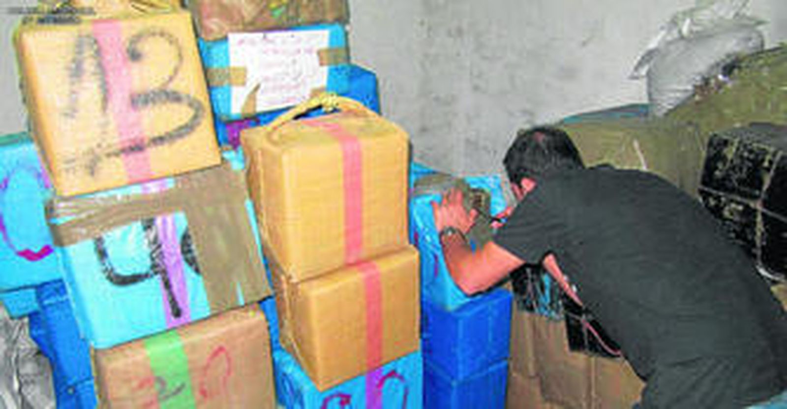 Un agente de Policía inspecciona la droga incautada en la operación en Torrox.