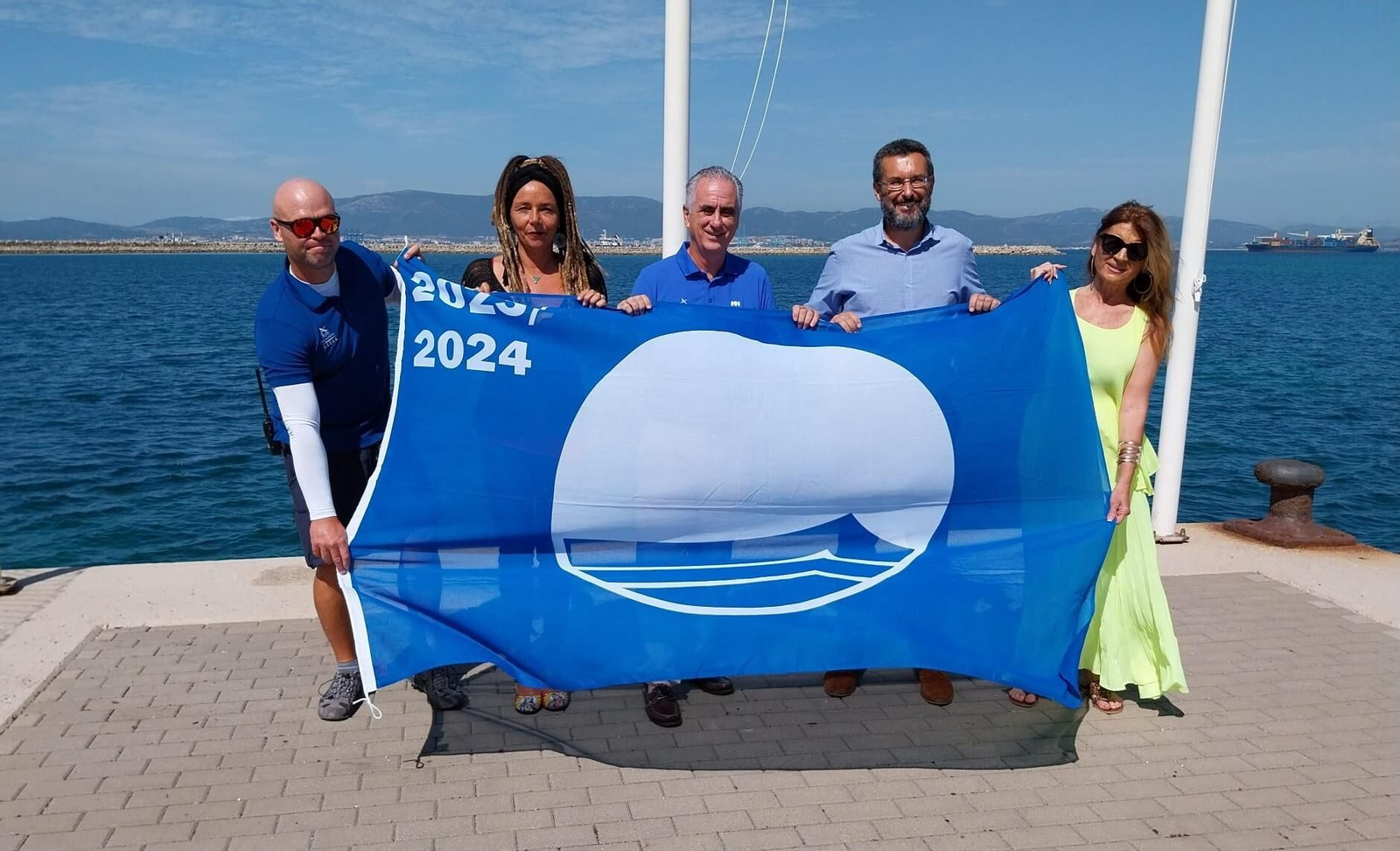 Los representantes municipales y de Alcaidesa Marina, con la bandera azul.