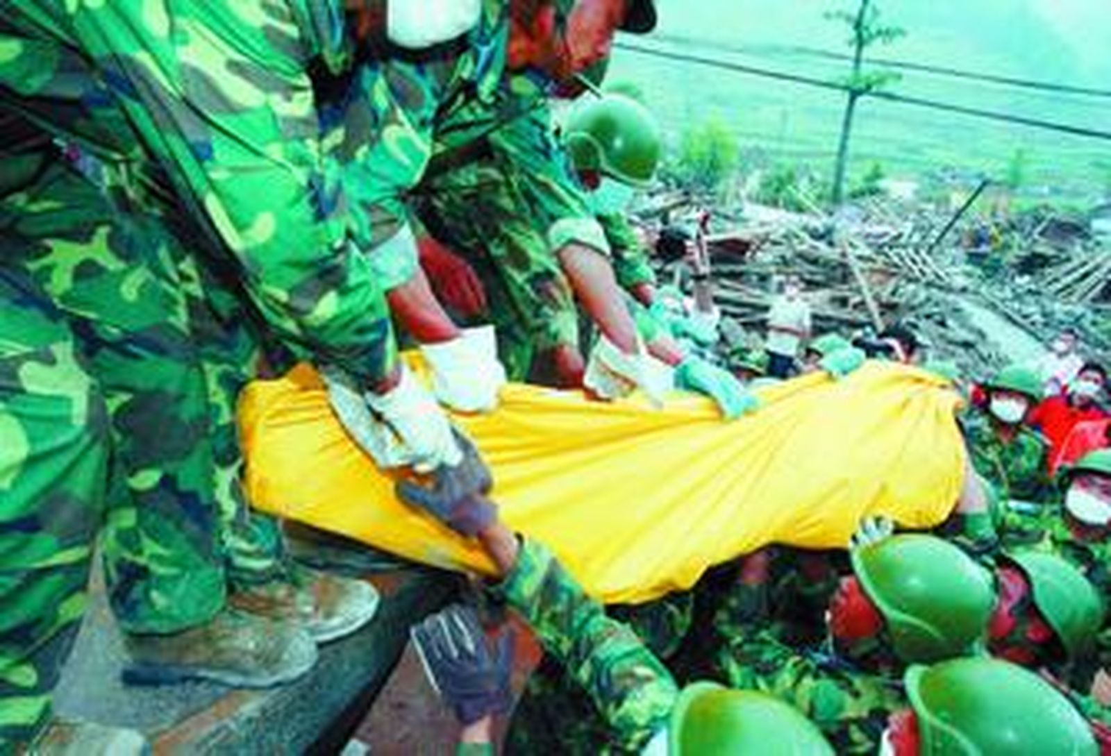 Soldados sacan un cadáver entre los escombros.