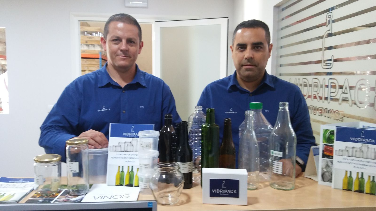 Los dos impulsores de la firma Vidripack, junto a algunas de sus botellas y envases.