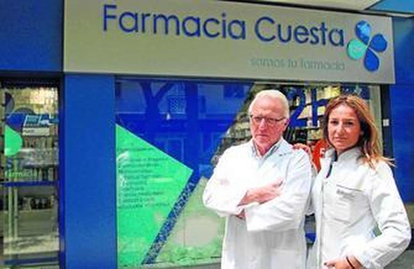 Miguel y Laura Cuesta, ayer, en la puerta de su farmacia, con el escaparate destrozado por el ladrón.