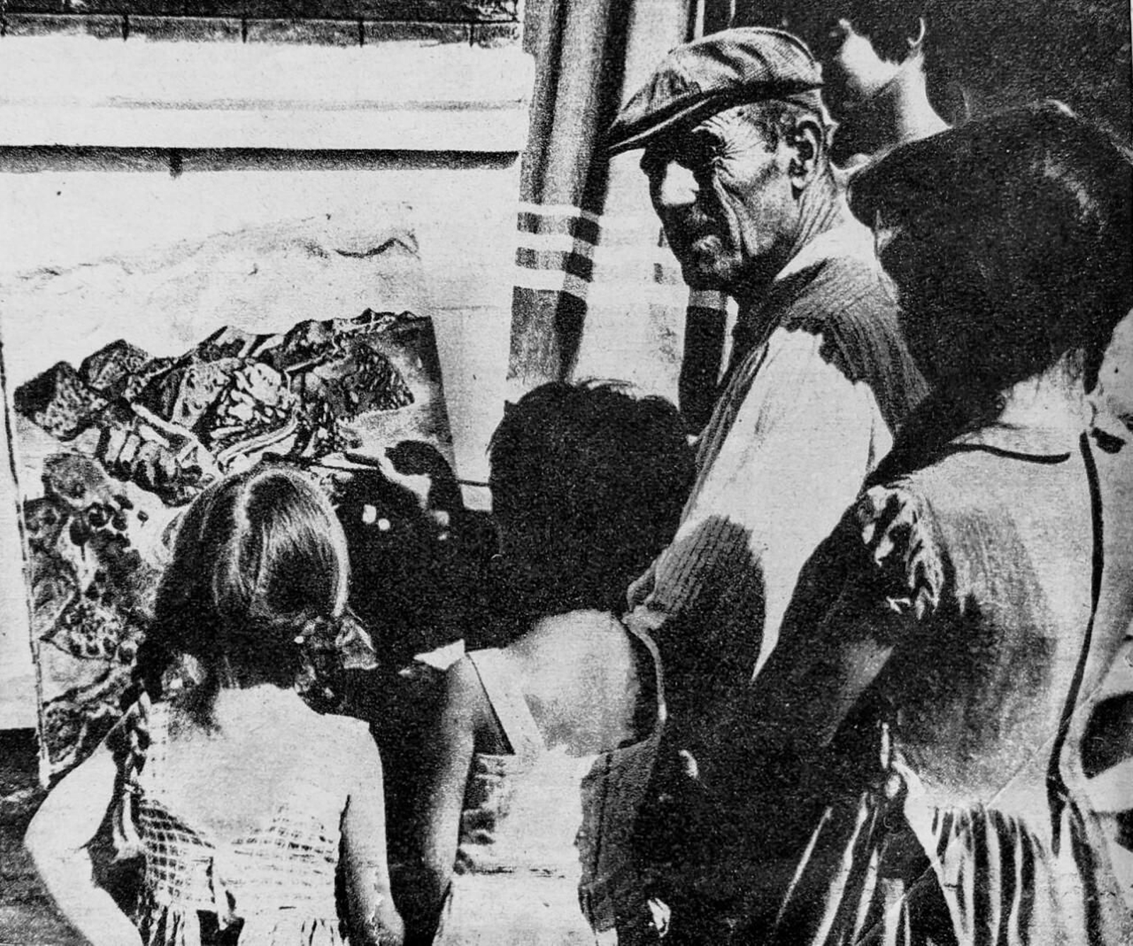 El pintor mostrando una de sus obras.