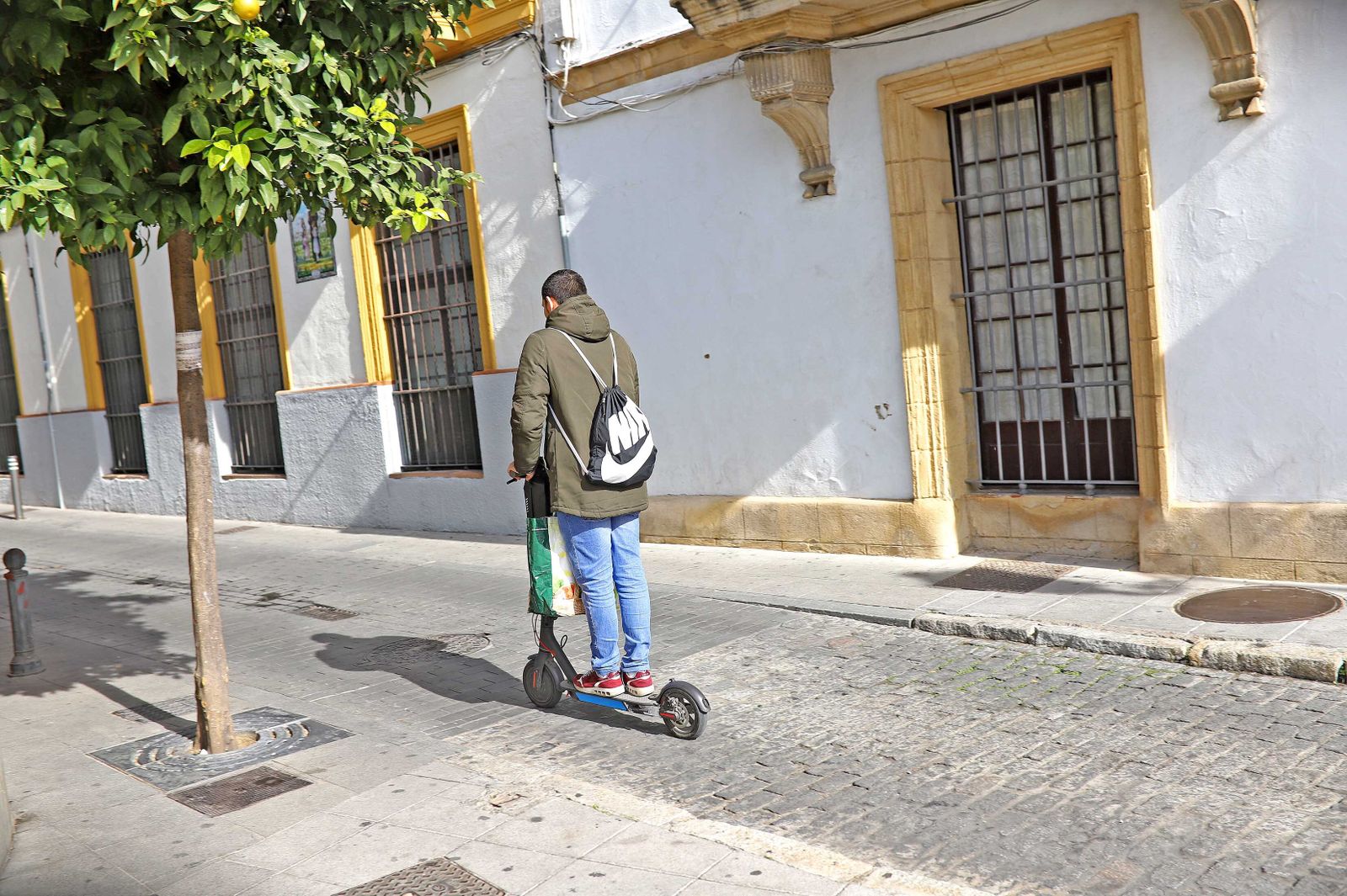 Un joven, circulando con su patinete eléctrico por el centro.