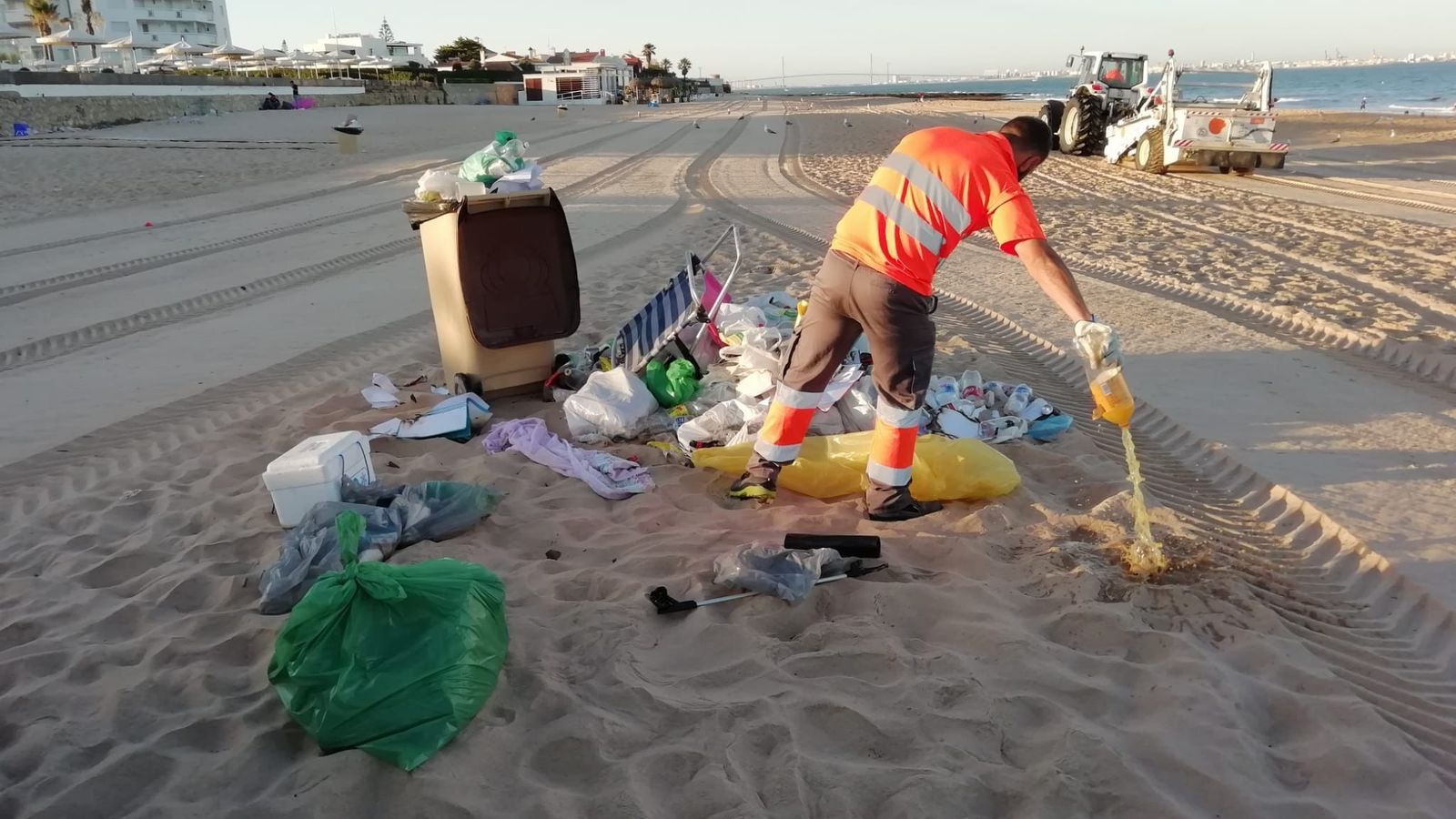 Un operario de playas, limpiando los restos de uno de los botellones esta mañana.