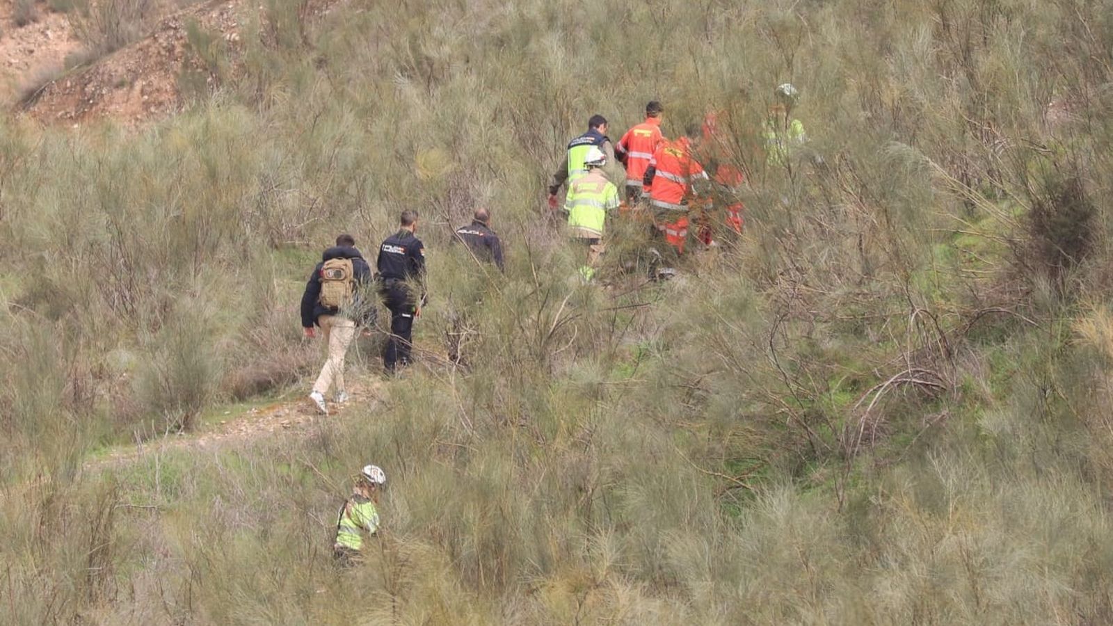 Agentes de Homicidios de la Guardia Civil y Bomberos transportan el cadáver desde la zona en la que ha aparecido cerca del Campus de Cartuja