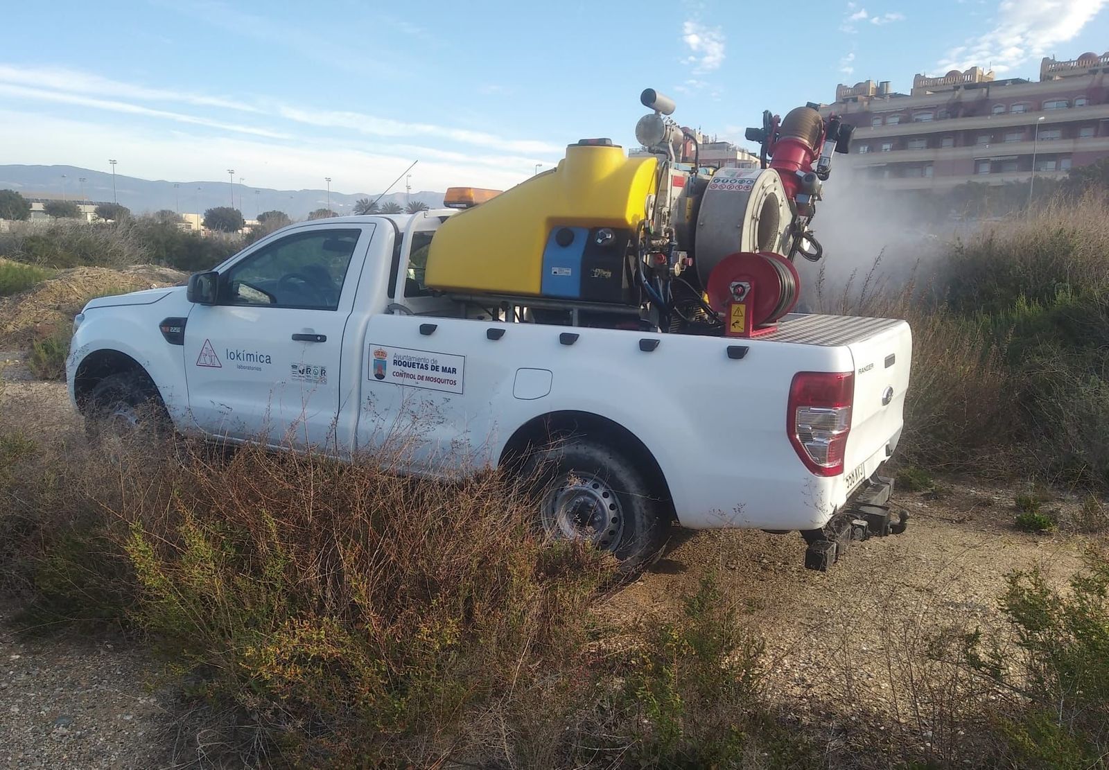 Un vehículo municipal fumiga en Roquetas de Mar contra los mosquitos.