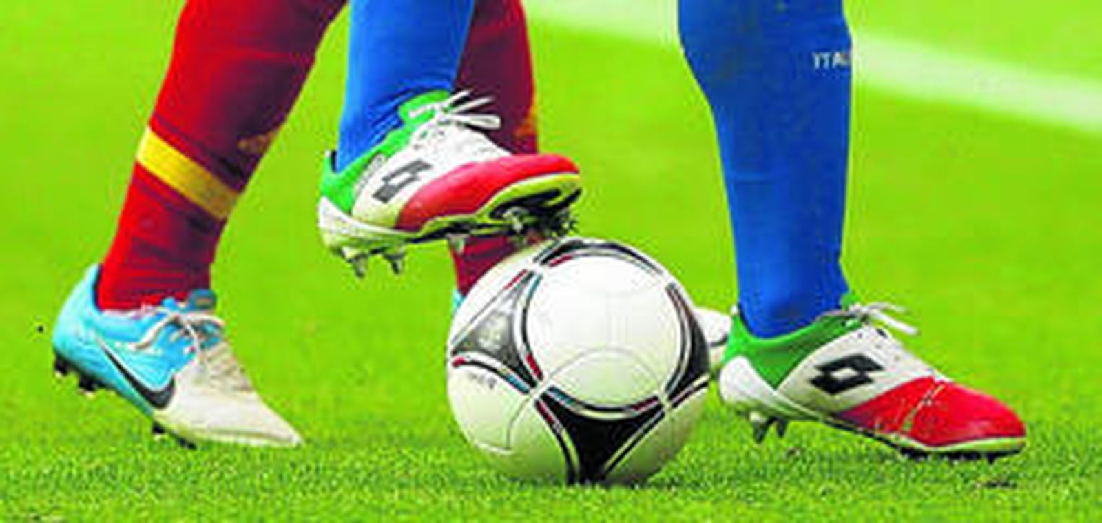 Iniesta y Maggio disputan un balón sobre el criticado césped del Gdansk Arena, donde España jugará también ante Irlanda y Croacia.