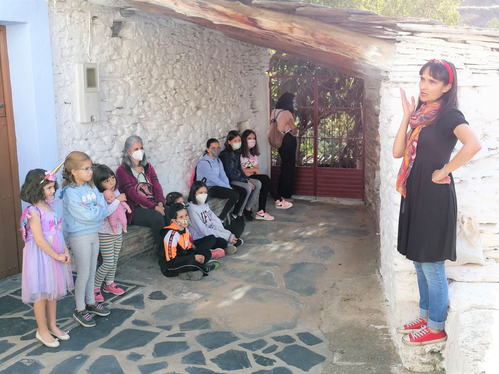 Paula Mandarina contando un cuento en la zona de La Moraleda ante un grupo de niños y  mayores.