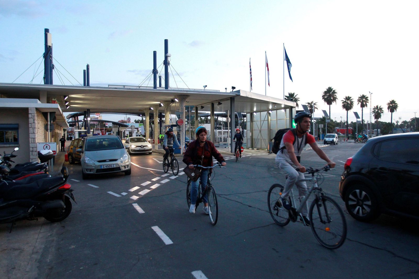 Varias personas entran en Gibraltar en bicicleta.
