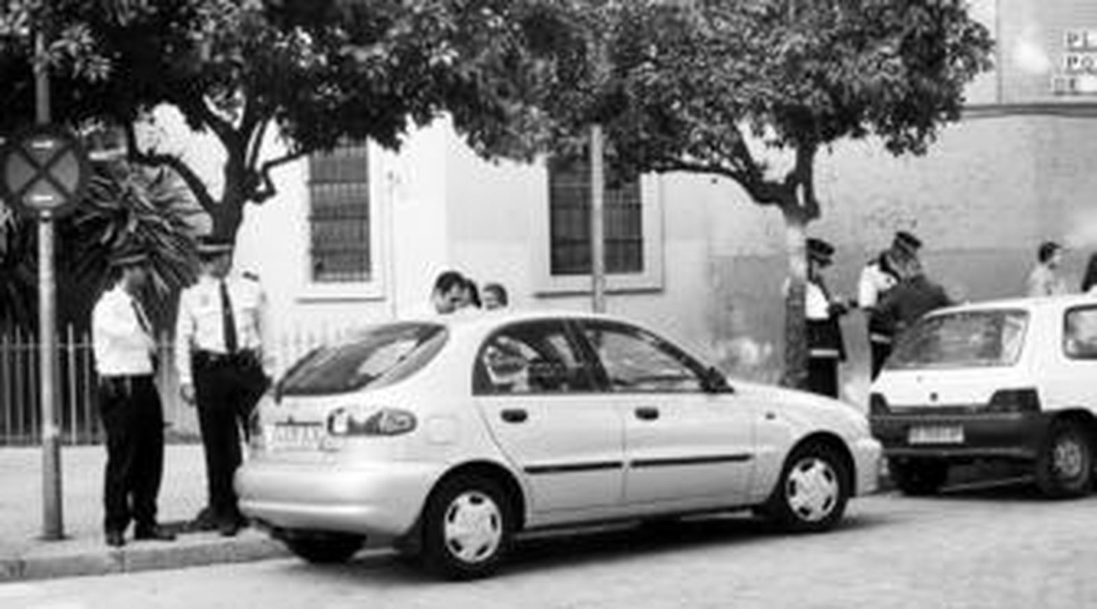 Varios policías imponen sanciones a vehículos mal aparcados, en una imagen de archivo.