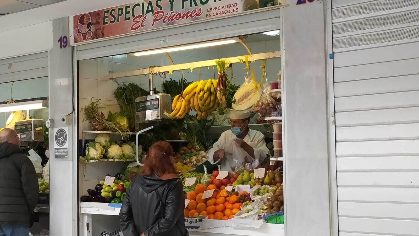Un frutero del Mercado de San Antonio atiende a una clienta.