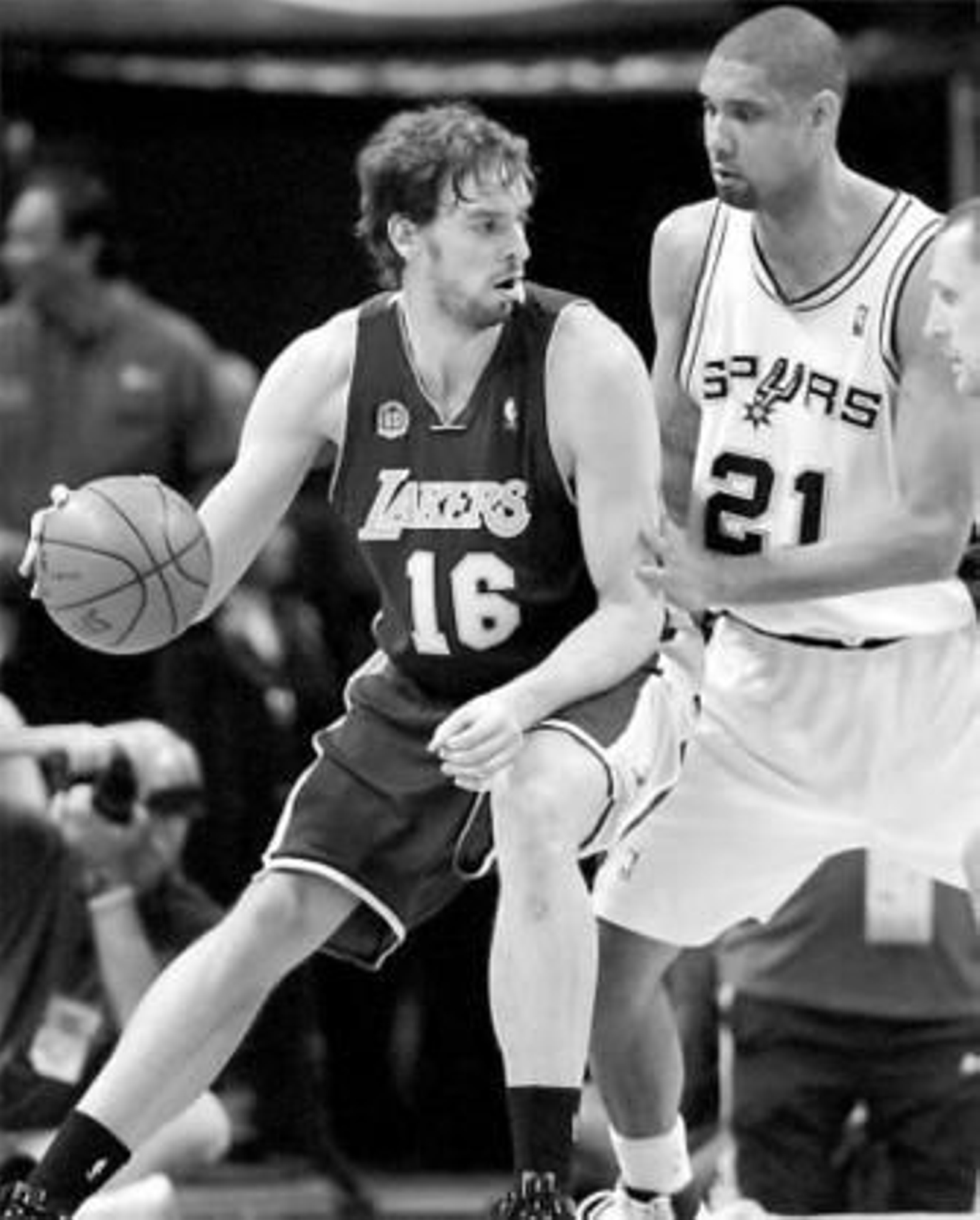 Tim Duncan trata de frenar el ataque de Pau Gasol.
