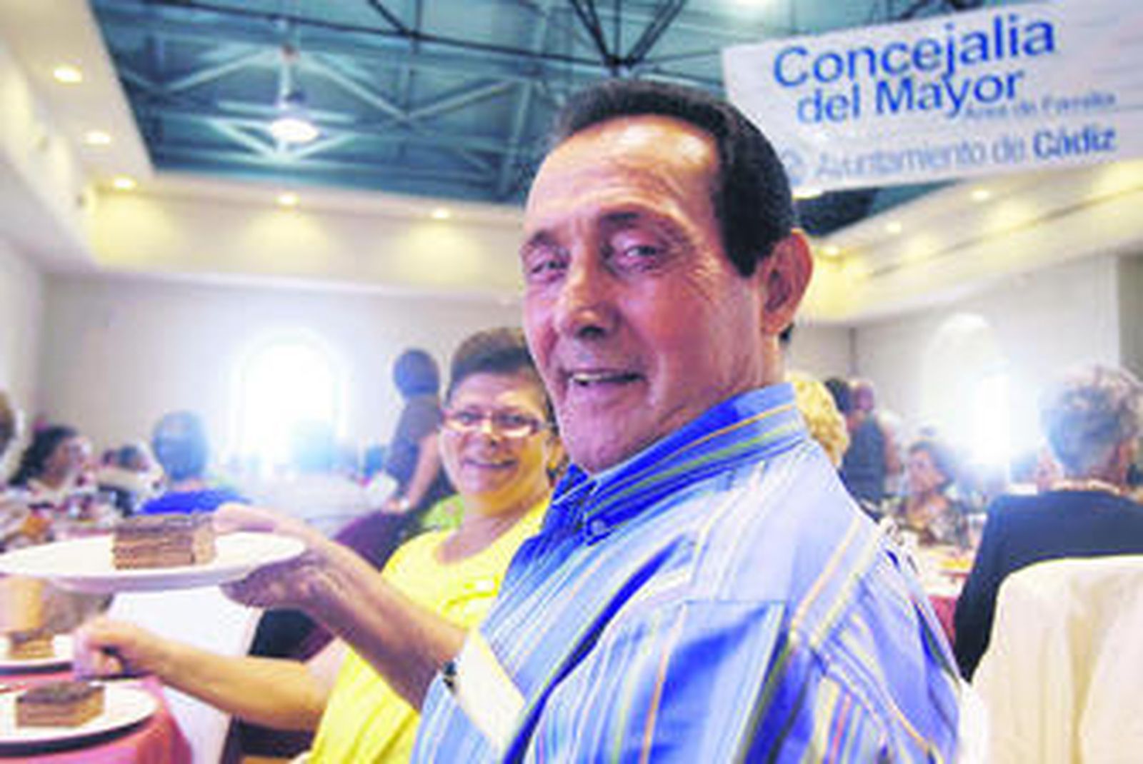 Dos de los asistentes a la merienda de ayer muestran sonrientes su porción de pastel de chocolate.