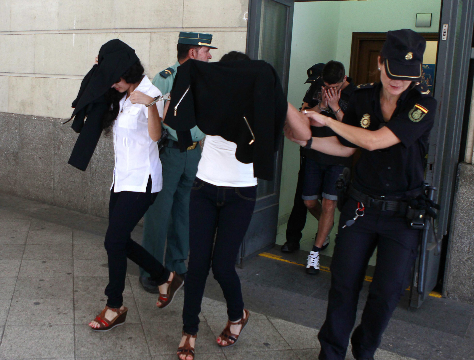Las dos cuñadas y el novio de una de ellas, salen escoltadas de los juzgados de Sevilla tras comparecer ante el juez.