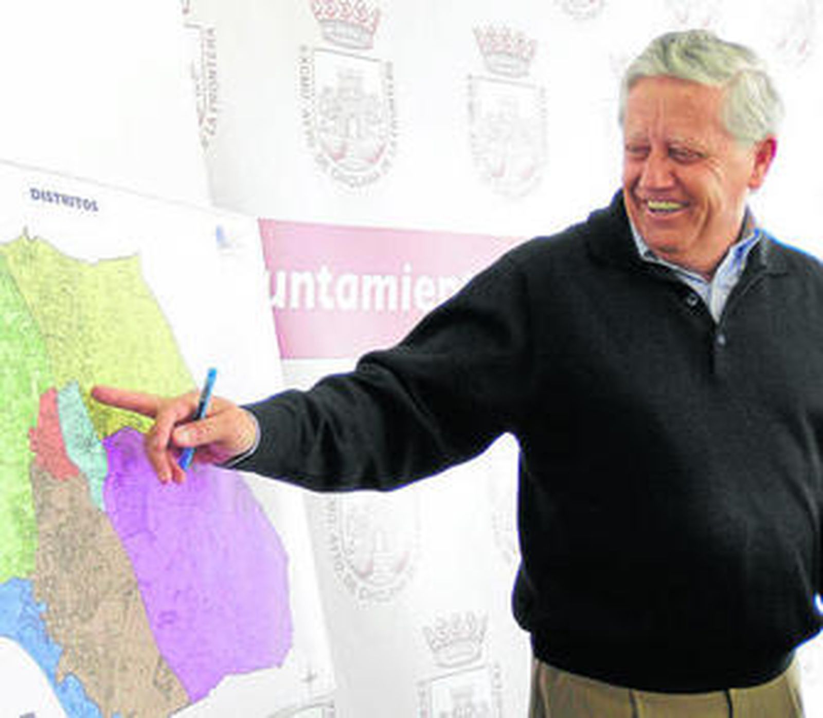 El alcalde señala el plano con los distritos en el transcurso de su comparecencia ante la prensa.