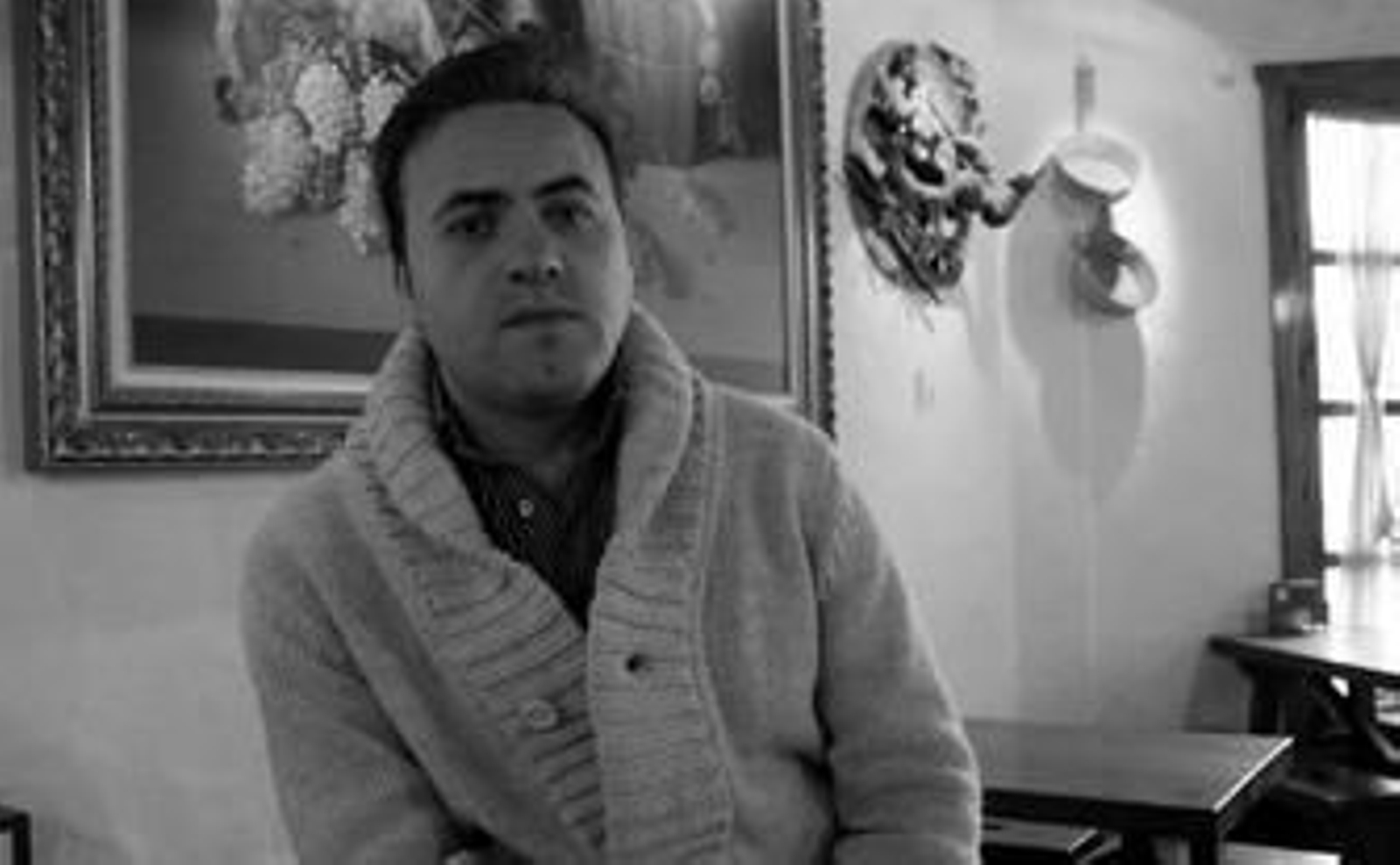 Ismael García posa sentado en una de las mesas de Bodega Jerezana, propiedad de su familia.