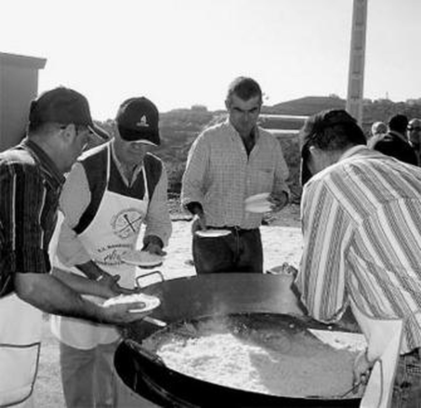 Vecinos de Torrox reparten raciones de migas en la última edición.
