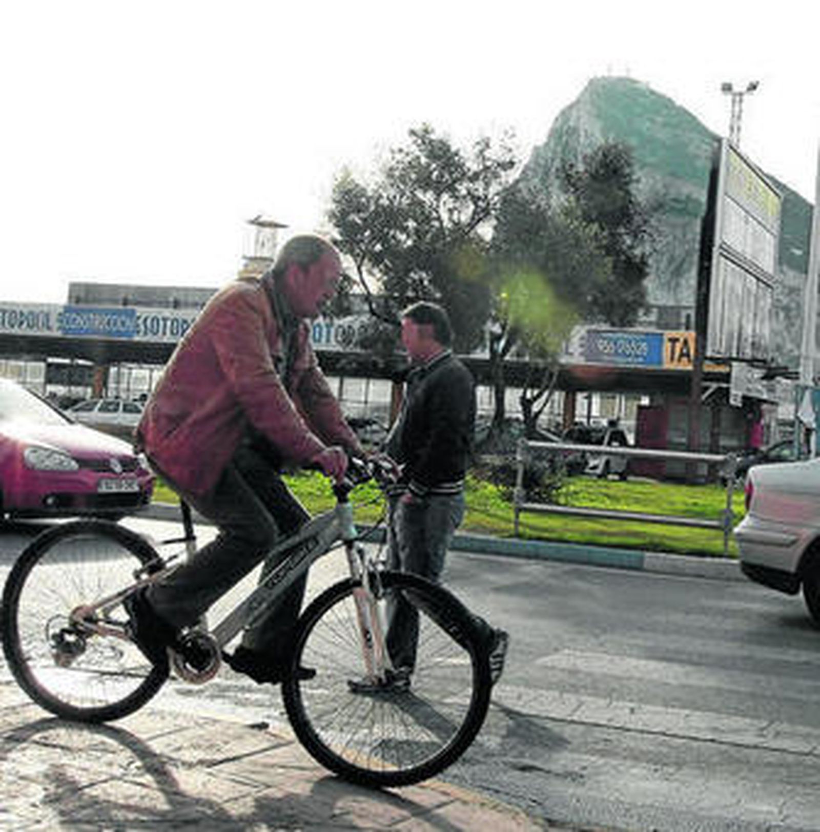 Un hombre pasa en bicicleta por delante de la entrada a Gibraltar.