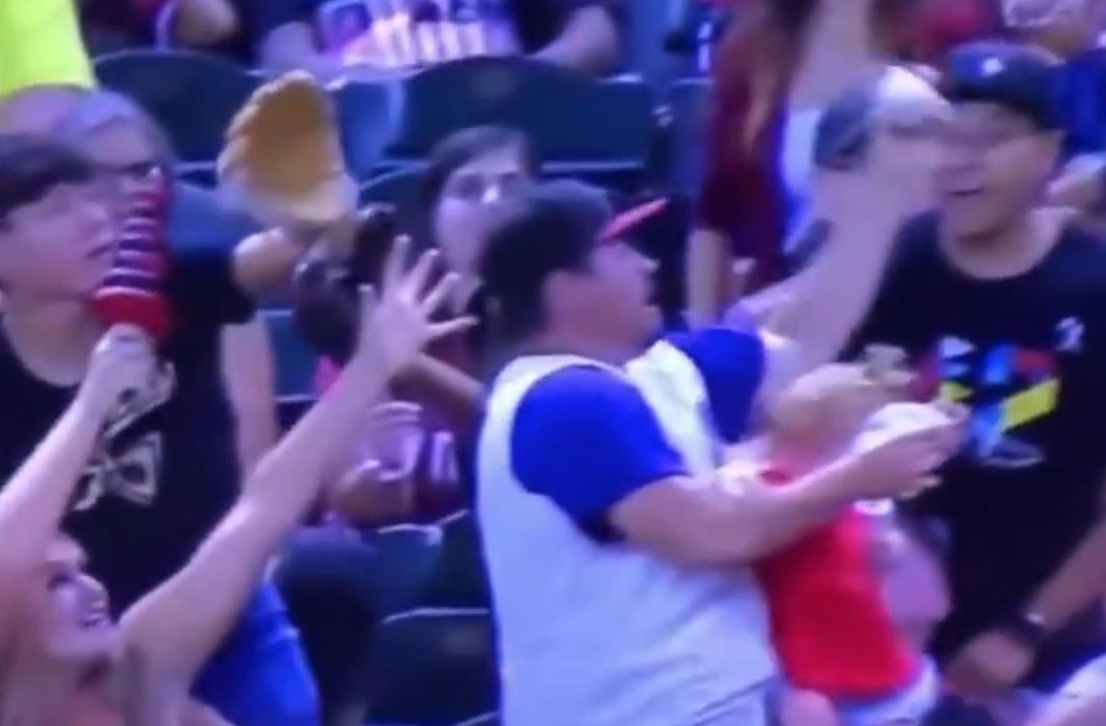 Momento en el que el hombre agarra la pelota de béisbol y arriesga la seguridad de la niña