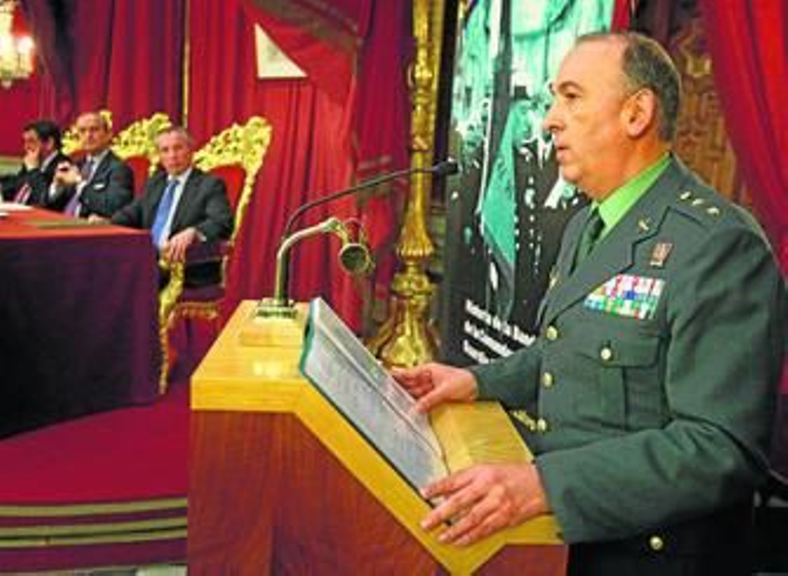 El conferenciante, el teniente coronel Jesús Núñez, con la presidencia del acto al fondo.