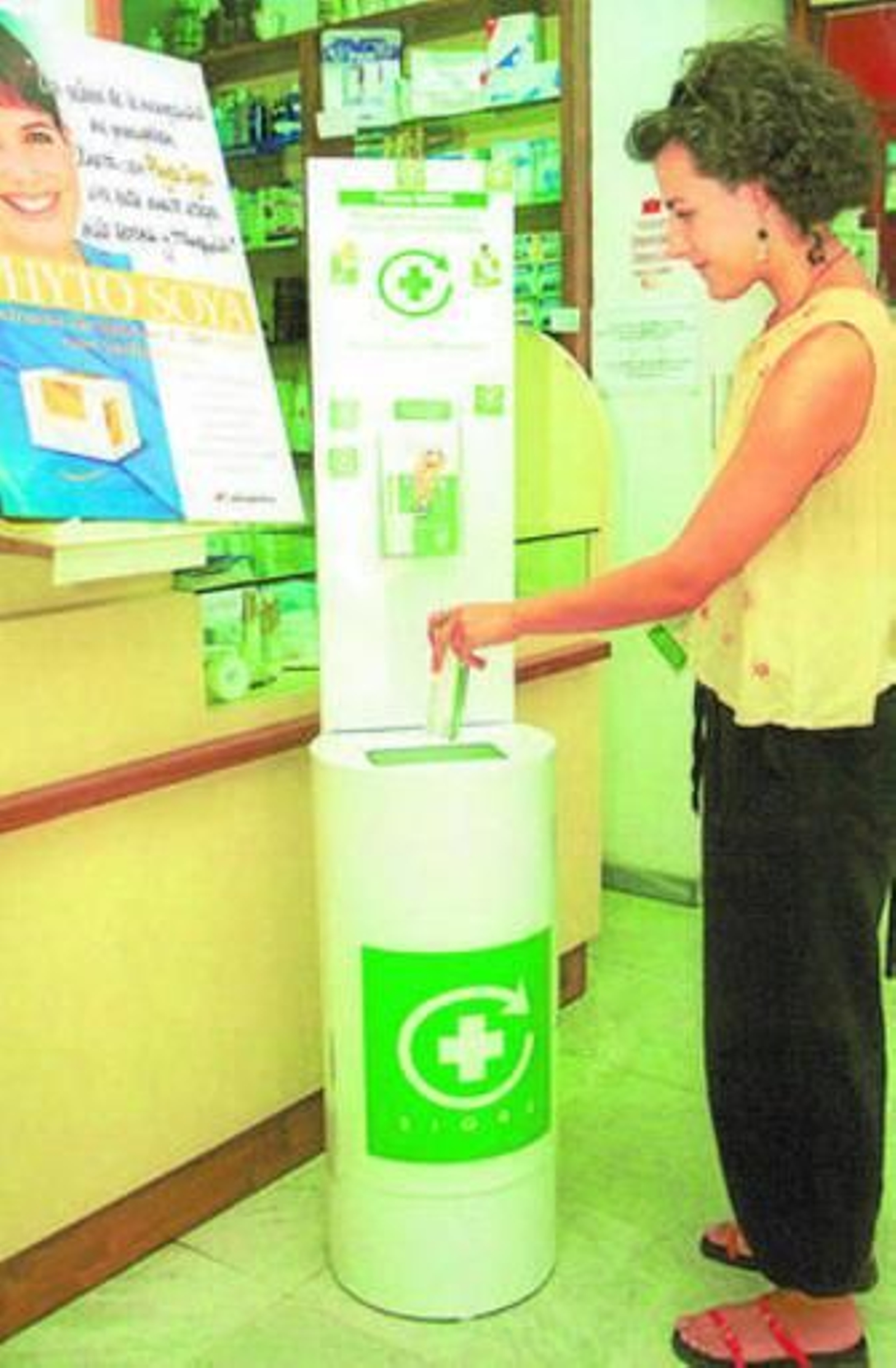 Una ciudadana deposita las medicamentos en un Punto Sigre.